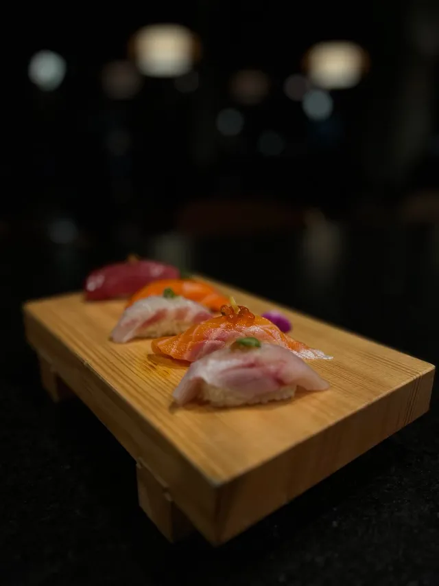 Nigiri tasting on a wooden board: tuna, salmon and yellowtail